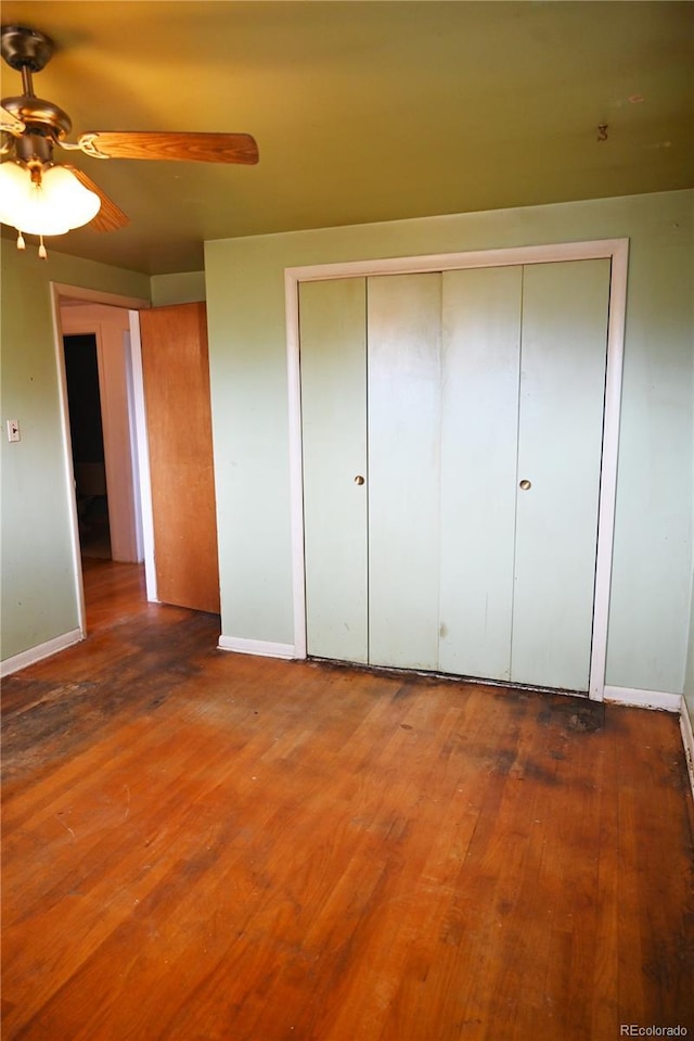 unfurnished bedroom featuring wood-type flooring, ceiling fan, and a closet