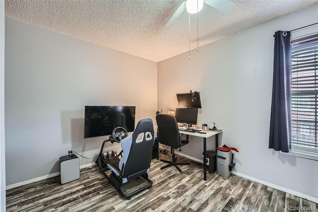 home office featuring a textured ceiling, wood finished floors, a ceiling fan, and baseboards
