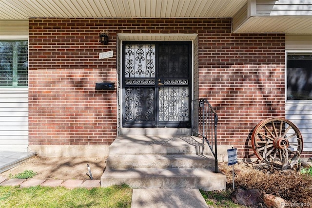 entrance to property featuring brick siding