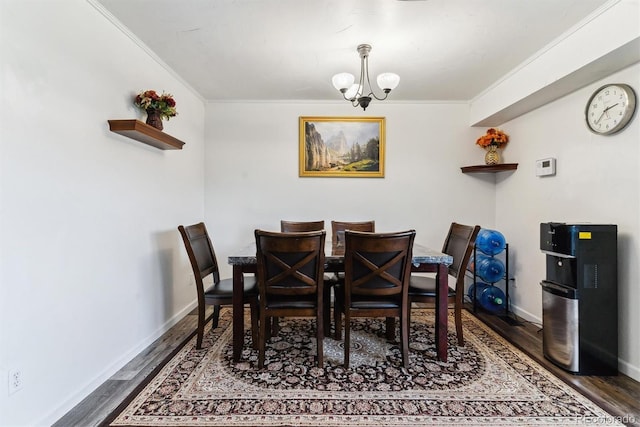 dining room featuring baseboards, wood finished floors, an inviting chandelier, and ornamental molding