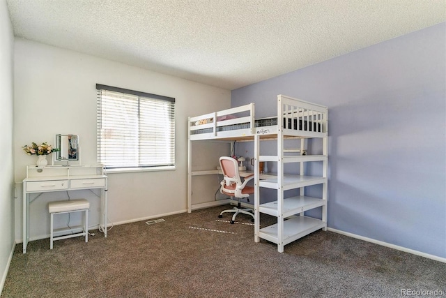 bedroom with carpet flooring, baseboards, and a textured ceiling