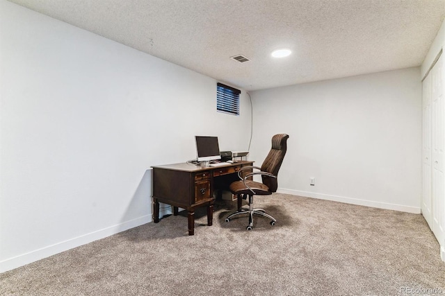 office space featuring a textured ceiling, carpet, visible vents, and baseboards