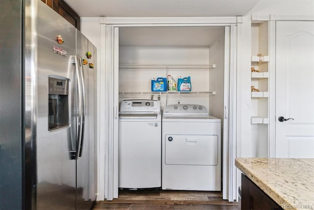 washroom featuring washer and dryer, dark wood-type flooring, and laundry area