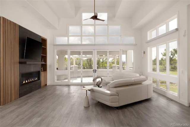 4935 E Preserve Ln, Greenwood Village, CO 80121 - living room featuring ceiling fan, wood finished floors, french doors, a large fireplace, and a towering ceiling