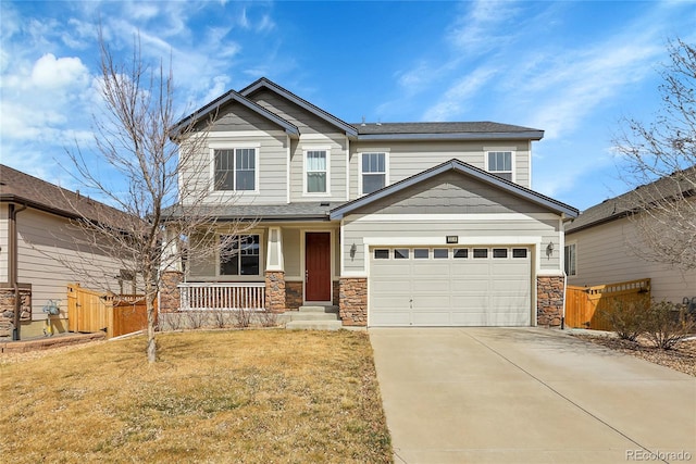 craftsman house featuring a porch, driveway, fence, a front lawn, and stone siding