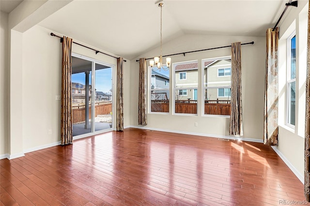 unfurnished dining area featuring baseboards, lofted ceiling, a notable chandelier, and hardwood / wood-style floors