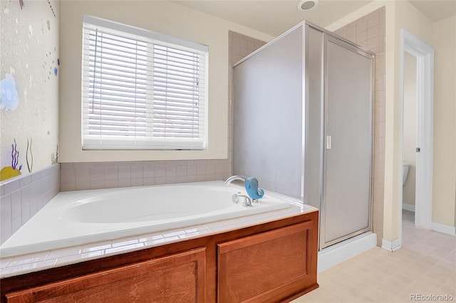 bathroom with tile patterned floors, a stall shower, and a garden tub
