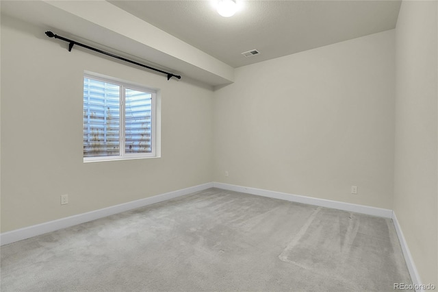 carpeted empty room featuring visible vents and baseboards