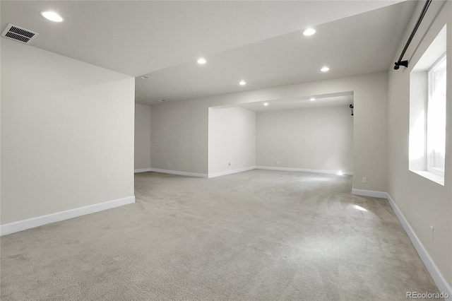 spare room with light carpet, recessed lighting, and visible vents