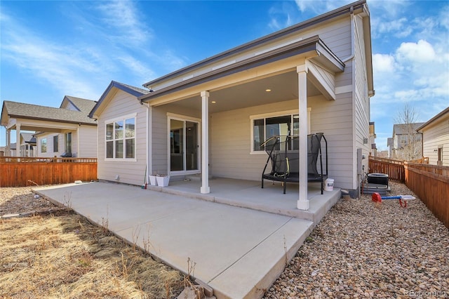rear view of house featuring a fenced backyard and a patio area