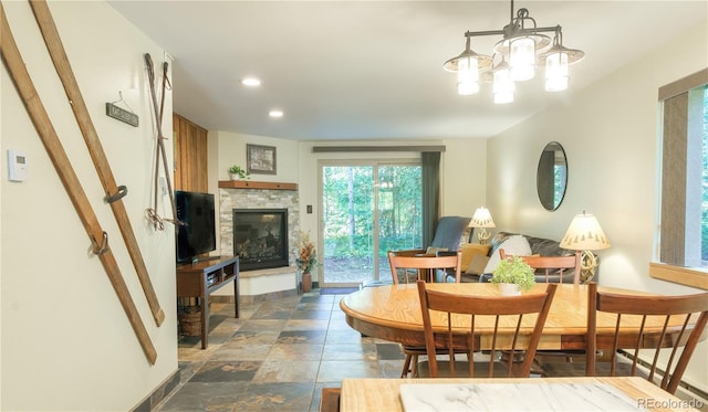 dining area featuring a notable chandelier and a fireplace