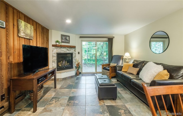 living room featuring a fireplace and wood walls