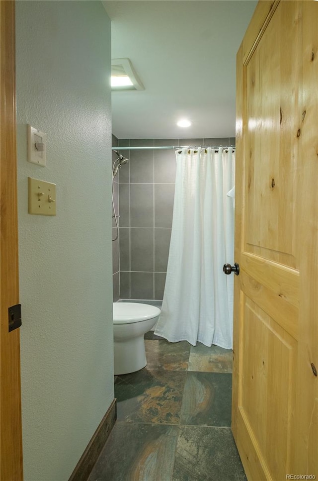 bathroom featuring toilet and walk in shower