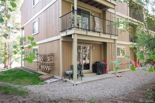 rear view of property featuring a patio and a balcony