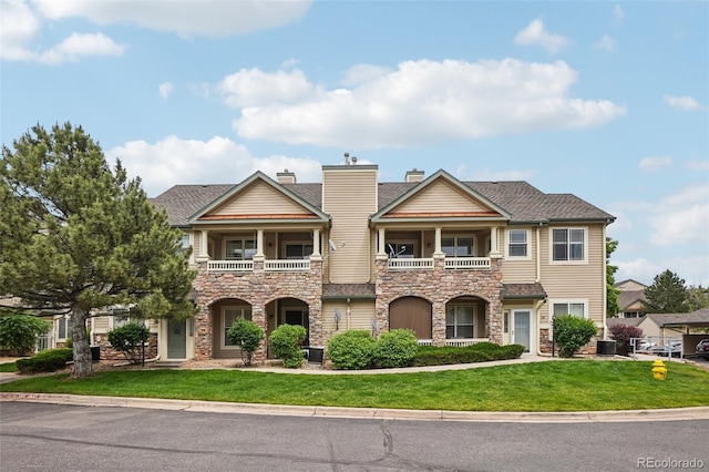 9692 W Coco Cir Unit 304, Littleton, CO 80128 - townhome / multi-family property featuring a balcony, stone siding, and a front lawn