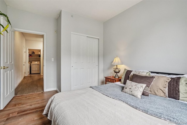 9692 W Coco Cir Unit 304, Littleton, CO 80128 - bedroom with wood finished floors, a closet, washing machine and dryer, and baseboards