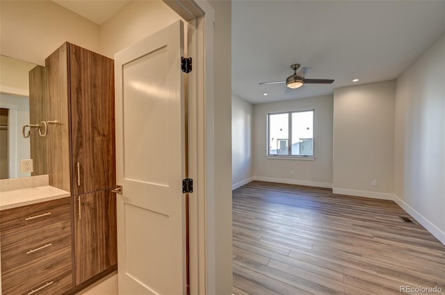 bathroom with ceiling fan, vanity, and wood-type flooring