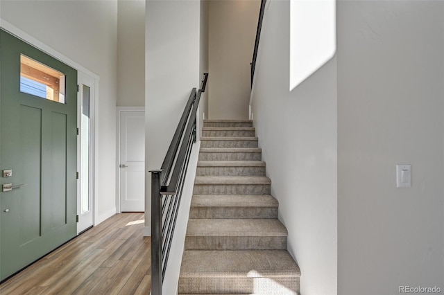 staircase with hardwood / wood-style floors and a healthy amount of sunlight