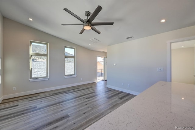 unfurnished room featuring ceiling fan, wood-type flooring, and vaulted ceiling