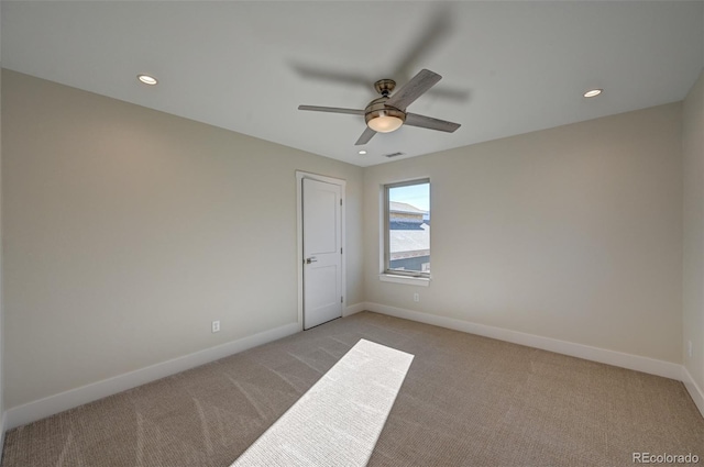 carpeted spare room with ceiling fan