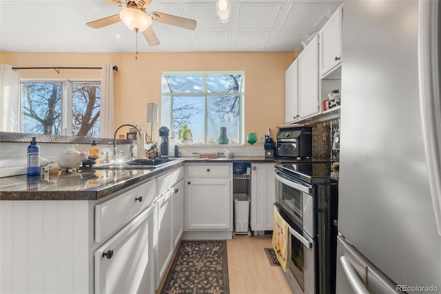17467 E Rice Cir Unit C, Aurora, CO 80015 - kitchen featuring appliances with stainless steel finishes, light wood finished floors, a ceiling fan, white cabinetry, and a peninsula