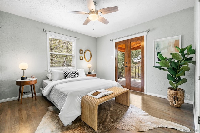 bedroom featuring a textured wall, access to exterior, baseboards, and wood finished floors