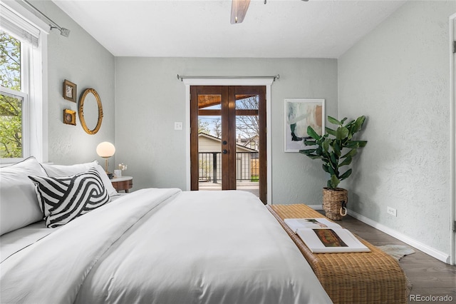 bedroom with multiple windows, a textured wall, dark wood finished floors, and access to exterior