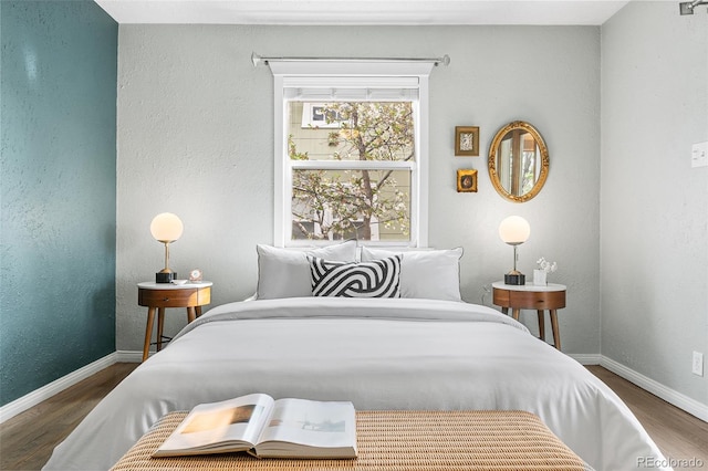 bedroom with baseboards and wood finished floors