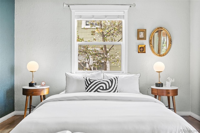bedroom featuring baseboards and dark wood-style floors