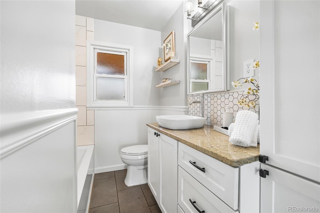 full bath featuring a washtub, backsplash, tile patterned flooring, vanity, and toilet