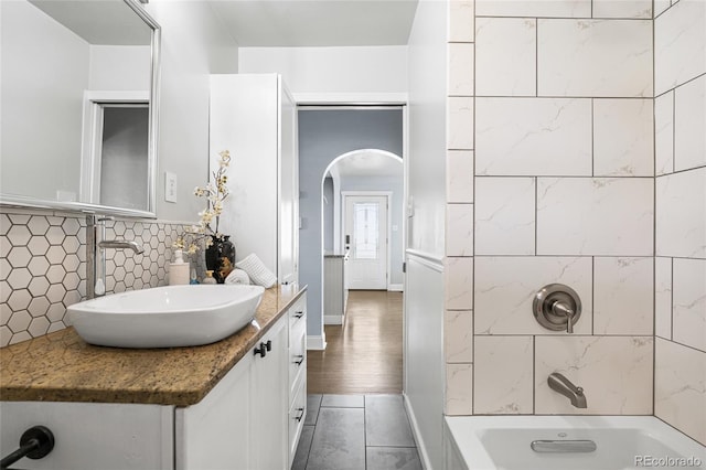 full bath featuring vanity, tasteful backsplash, tile patterned floors, and tub / shower combination