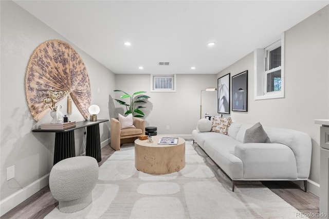 living area featuring recessed lighting, baseboards, and light wood-type flooring