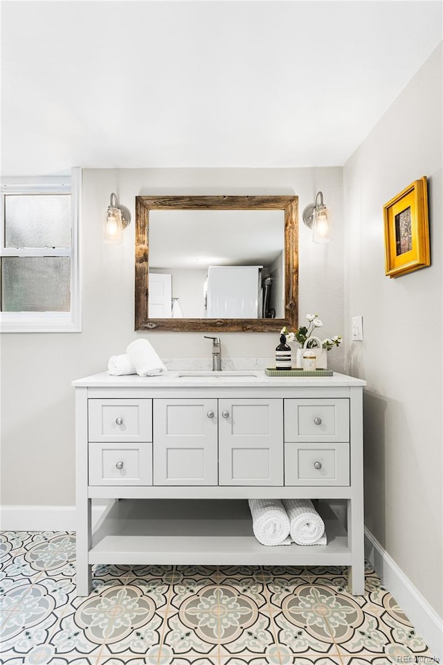 bathroom with vanity, baseboards, and tile patterned flooring