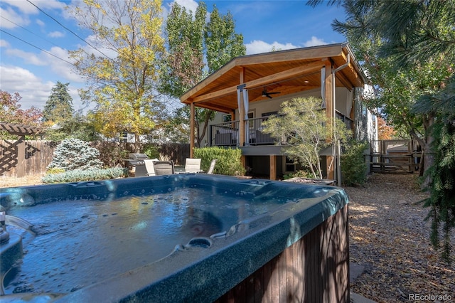 view of pool featuring ceiling fan, a hot tub, and fence private yard