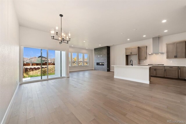 1724 Barefoot Dr, Windsor, CO 80550 - unfurnished living room with a chandelier, light wood finished floors, baseboards, recessed lighting, and a sink
