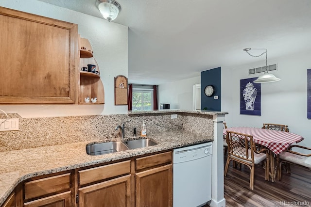 kitchen with dishwasher, light stone counters, a sink, and visible vents