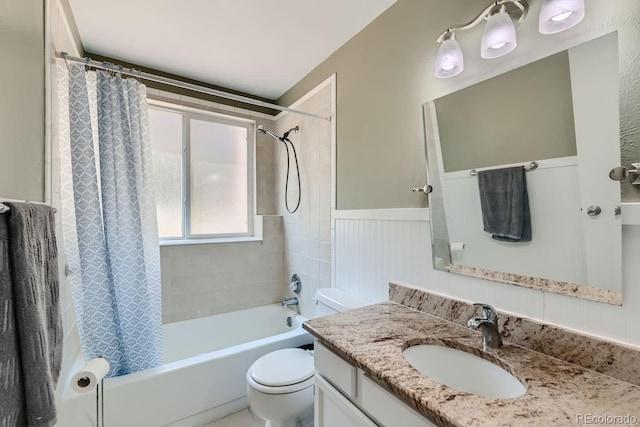 bathroom featuring wainscoting, shower / tub combo with curtain, vanity, and toilet