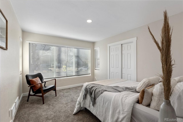 carpeted bedroom with a closet, visible vents, and baseboards