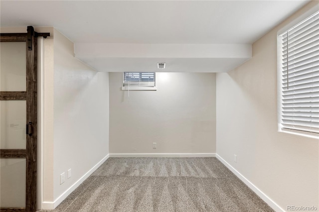 basement featuring light carpet, visible vents, and baseboards