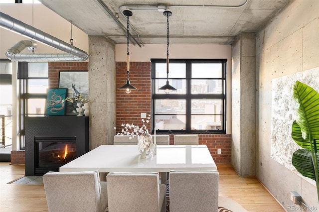 dining area featuring a glass covered fireplace and light wood-style flooring