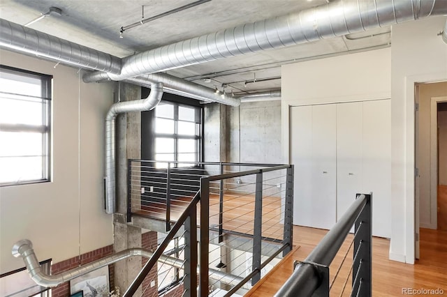 corridor featuring light wood-style flooring and an upstairs landing