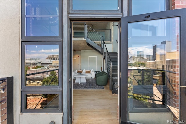 exterior space with stairs, a city view, and wood finished floors