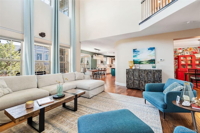 living room featuring baseboards, a high ceiling, and wood finished floors