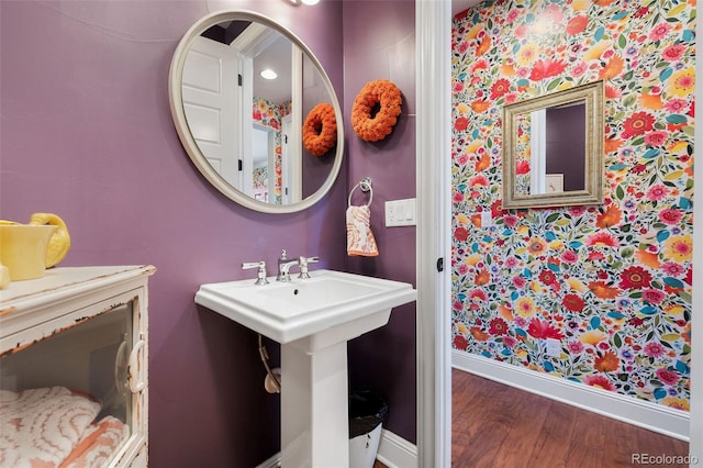 bathroom with a sink, baseboards, and wood finished floors