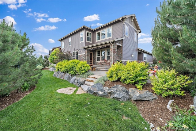 view of front facade with stone siding, board and batten siding, and a front yard