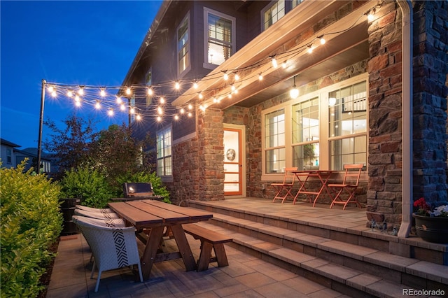 wooden deck with outdoor dining area and a patio