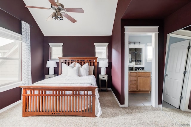 bedroom featuring carpet flooring, baseboards, vaulted ceiling, and ensuite bathroom
