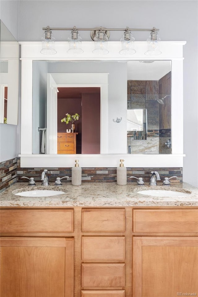 full bathroom featuring double vanity, a sink, and a shower