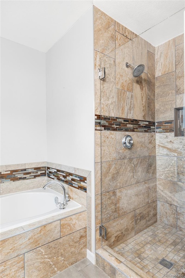 bathroom featuring a bath and a stall shower