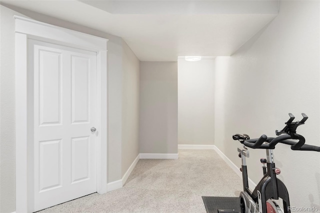 exercise room featuring baseboards and carpet
